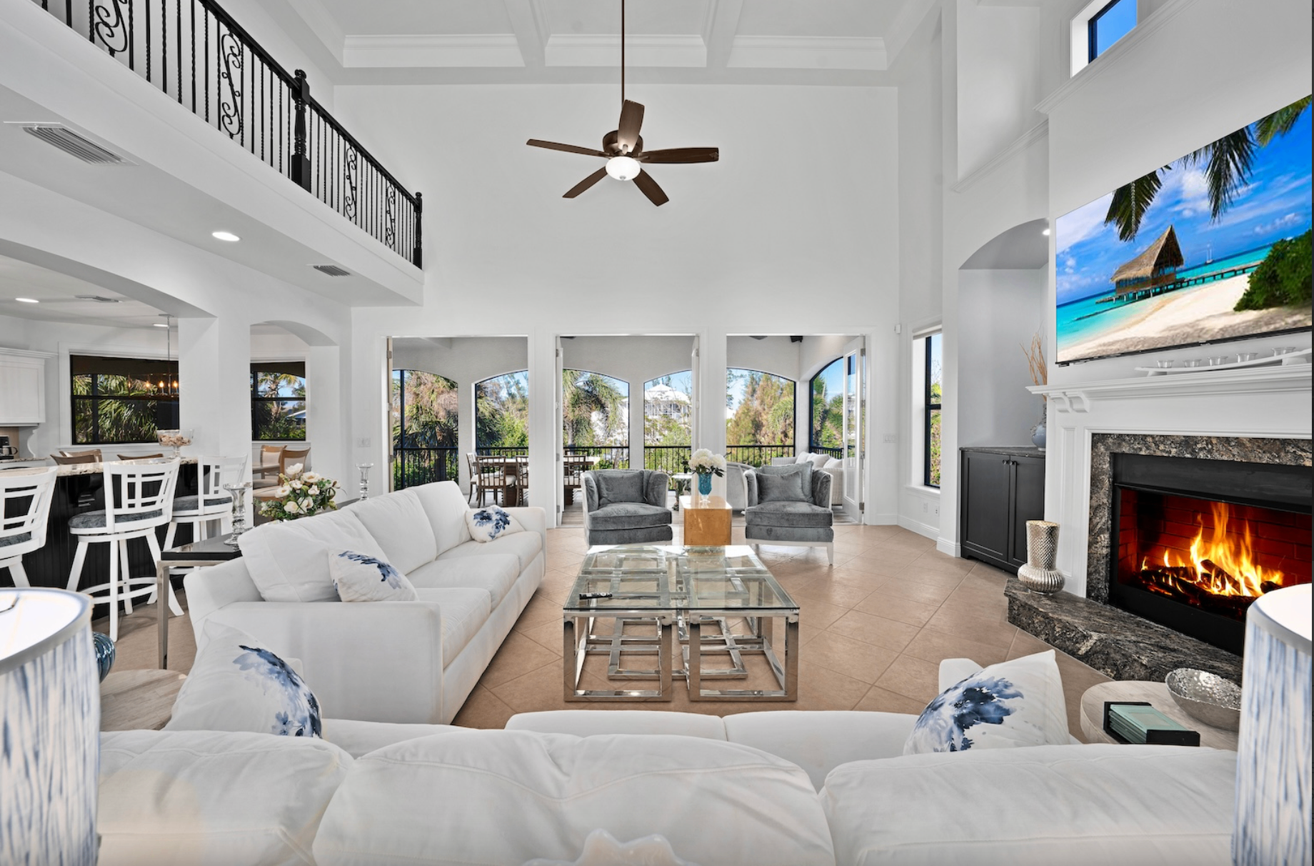 Interior great room at Dockside Dream — soaring ceilings, white sofas, fireplace