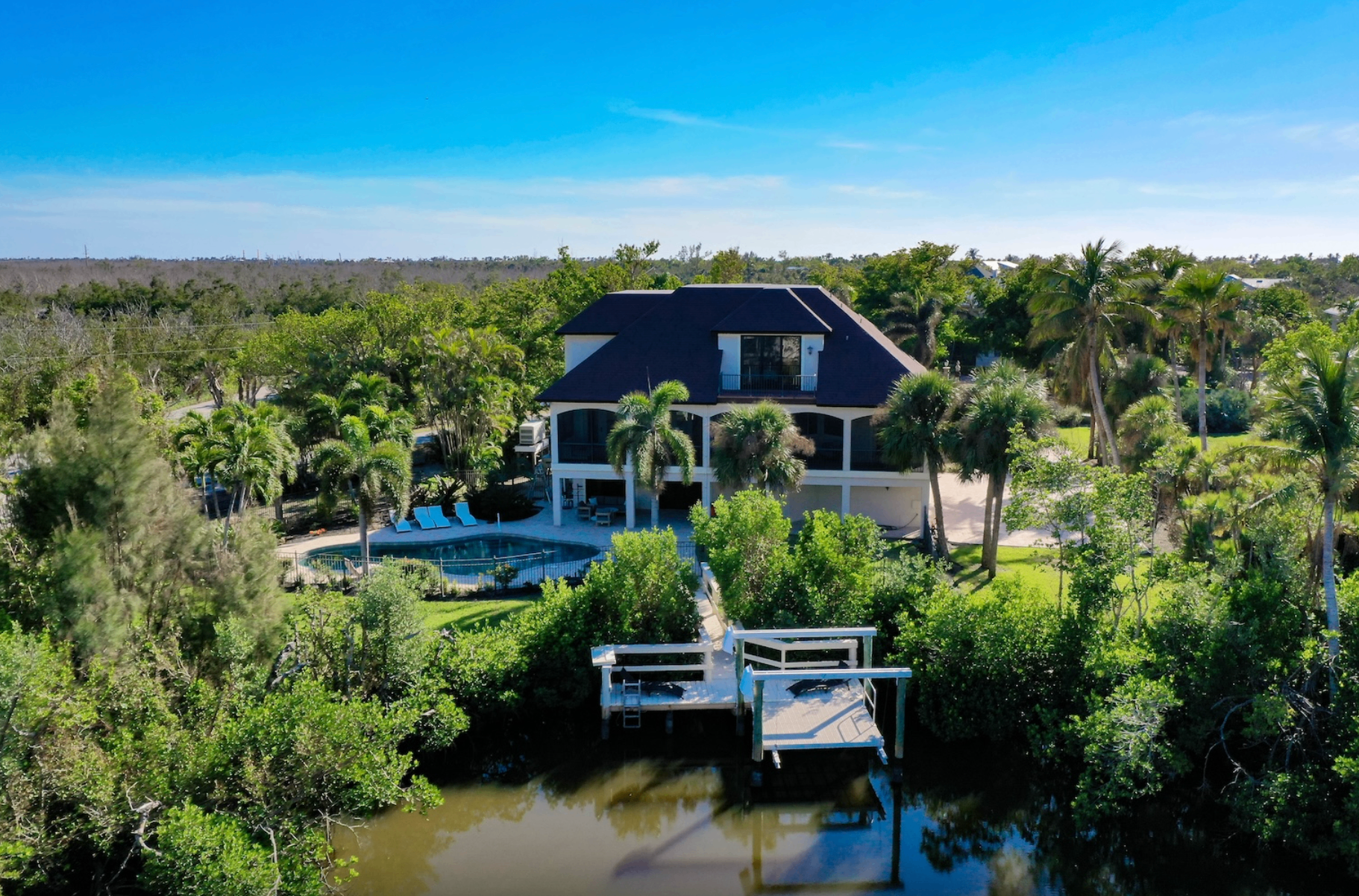 Aerial view of Dockside Dream — pool, dock, and bay